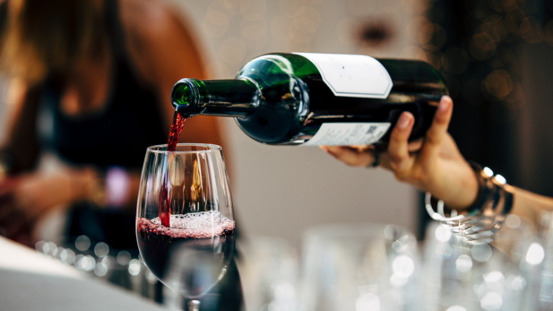 Image Of Someone Pouring Wine Into A Glass