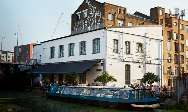 Image Of A Boat On A Canal Next To A Resturant.jpeg